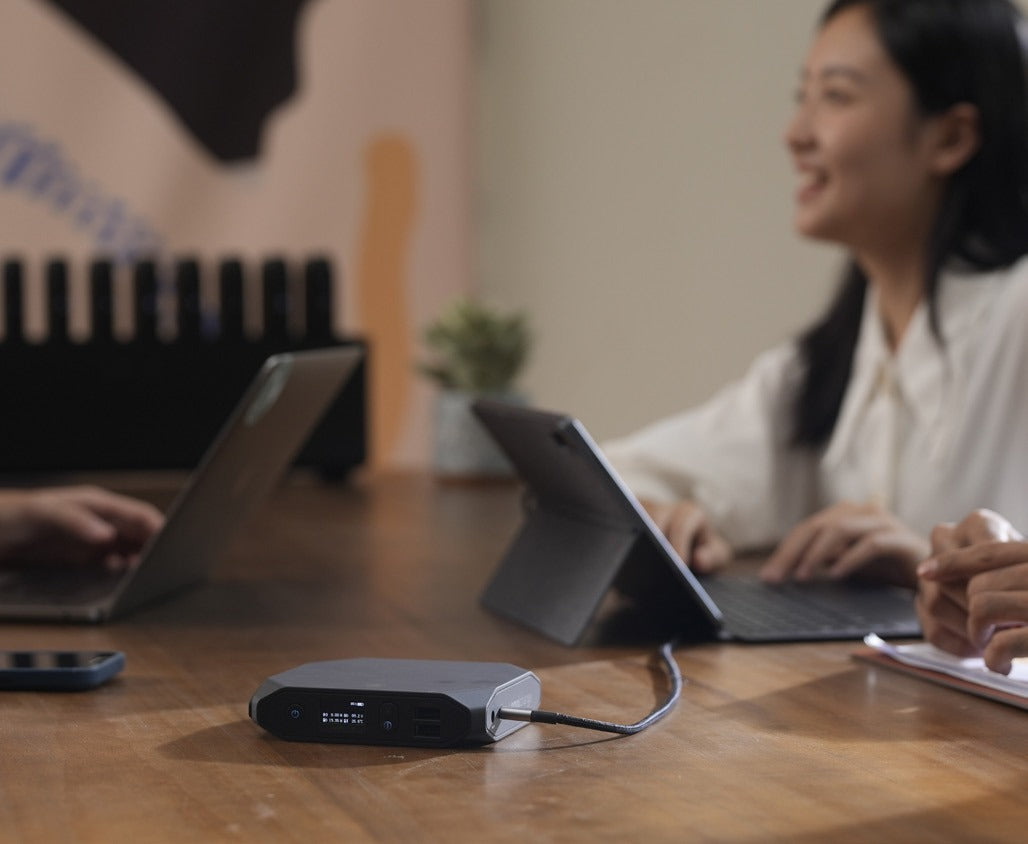 Employees in a cafe area using tablets with an Omni power bank